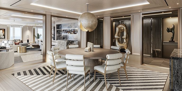 Round dining table with white chairs in a spacious ship suite
